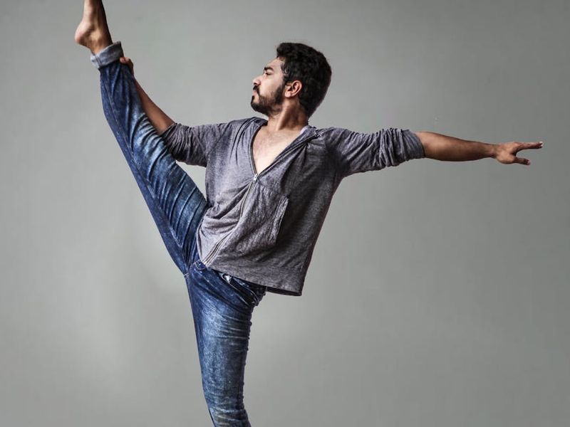 Person performing a flowing yoga movement in a minimalist room.